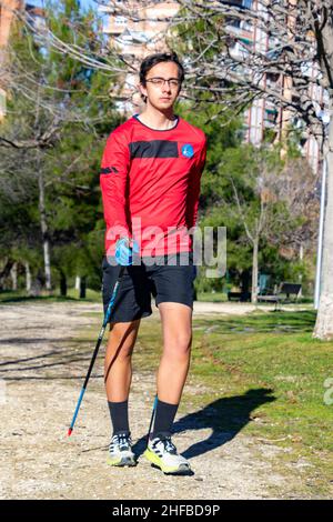 Marche nordique.Jeune pratiquant le sport marche nordique avec des bâtons dans un parc en plein air à Madrid, en Espagne.Europe.Photographie. Banque D'Images