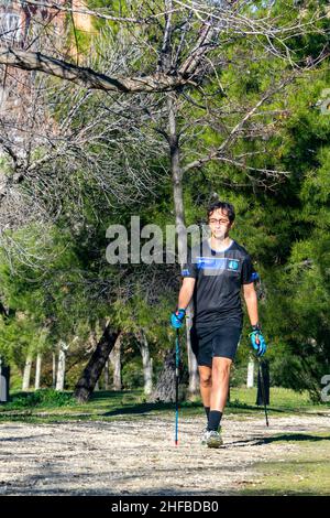 Marche nordique.Jeune pratiquant le sport marche nordique avec des bâtons dans un parc en plein air à Madrid, en Espagne.Europe.Photographie. Banque D'Images