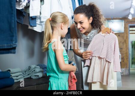 jeune femme et fille dans la boutique de vêtements. Banque D'Images