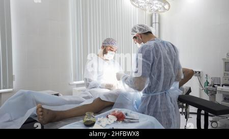 Processus chirurgical dans la salle d'opération stérile.Deux médecins professionnels effectuant la chirurgie réelle avec tout l'équipement nécessaire, backgroun médical Banque D'Images