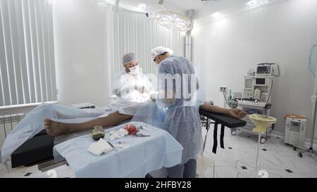 Processus chirurgical dans la salle d'opération stérile.Deux médecins professionnels effectuant la chirurgie réelle avec tout l'équipement nécessaire, backgroun médical Banque D'Images