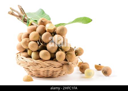 Fruits de longan frais avec feuilles dans un panier de bambou isolé sur fond blanc, Banque D'Images