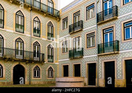 Immeuble d'appartements dans une cour avec balcons verts, décoré avec beaucoup de carreaux de céramique azulejos peints de couleur fine dans la ville de Lisbonne Banque D'Images