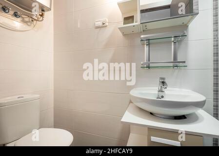 Petite salle de bains avec lavabo en porcelaine et toilettes Banque D'Images