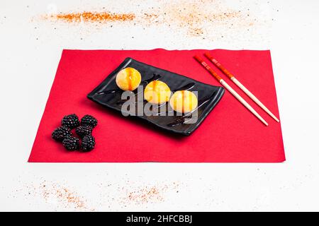 Au Japon, le riz collant est connu sous le nom de mochigome.Il est utilisé comme ingrédient dans la préparation du mochi, un gâteau de riz, celui-ci à la mangue et aux baies. Banque D'Images