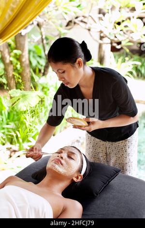 Femme recevant un soin du visage naturel rafraîchissant au pavillon de relaxation extérieur du spa Rebab à Kayumanis Gangsa, Bali, Indonésie. Banque D'Images