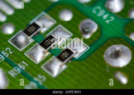 Plusieurs résistances CMS soudées sur une carte de circuit imprimé (PCB) verte. Banque D'Images