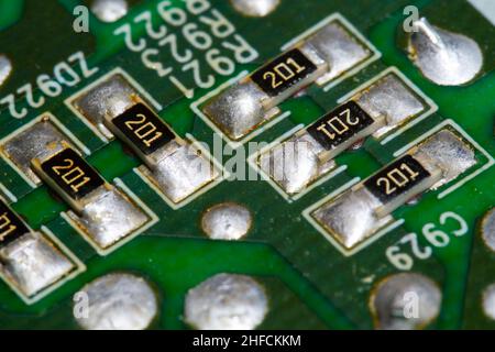 Plusieurs résistances CMS soudées sur une carte de circuit imprimé (PCB) verte. Banque D'Images