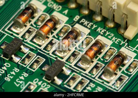 Inductances CMS soudées sur une carte de circuit imprimé (PCB) verte. Banque D'Images