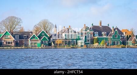 Panorama de maisons traditionnelles hollandaises en bois le long de l'eau d'un canal à l'emplacement célèbre de Zaanse Schans, Hollande. Banque D'Images