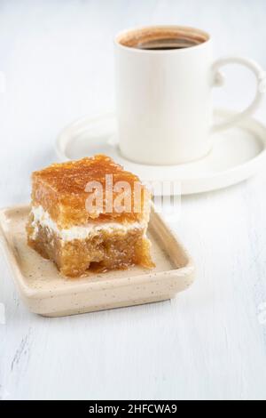 Tasse de café turc et dessert traditionnel avec crème connue sous le nom de 'ekmek kadayifi' en turc, en Turquie. Célèbre sucré traditionnel, gâteau au sirop Banque D'Images