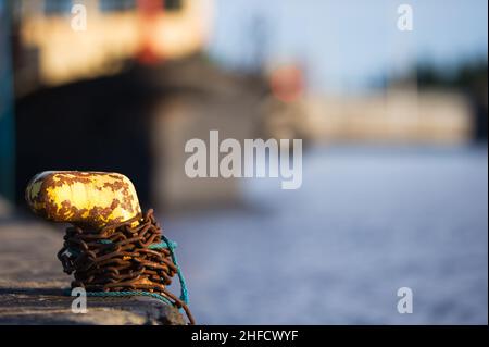 Chaîne rouillée autour du bollard métallique.Concentrez-vous sur le bollard. Banque D'Images