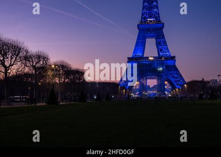 Vue sur la partie inférieure de la tour Eiffel depuis le champ de Mars au coucher du soleil Banque D'Images