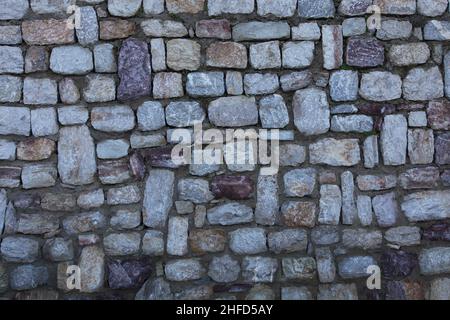 Stonewall fond.Un vieux mur en pierre fait à la main.Des pierres asymétriques sont utilisées.Gros plan. Banque D'Images