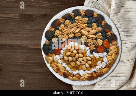 Assiette de fruits secs, fruits confits et noix sur une serviette de cuisine lumineuse Banque D'Images
