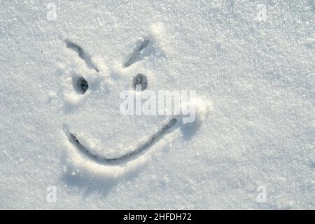 Visage d'un insidieux, en colère, souriant, peint sur la neige par un beau jour d'hiver.Copier l'espace.Vue de dessus. Banque D'Images