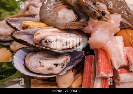 Accent sélectif sur les ingrédients de fruits de mer crus pour le hot pot, le sukiyaki asiatique, les bâtonnets de crabe de moules, le poisson et les crevettes. Banque D'Images