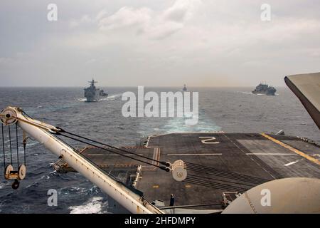 MER DE CHINE MÉRIDIONALE (JANV13, 2022) le quai d'atterrissage amphibie USS Pearl Harbor (LSC 52), à gauche, le destroyer à missile guidé USS Michael Murphy (DDG 112), au centre, et le navire de cargaison sèche et de munitions USNS Alan Sheppard (T-AKE 3) passent la mer de Chine du Sud avec le navire d'assaut amphibie USS Essex (LHD 2), janvier 13.Les opérations de la Force expéditionnaire mixte sont menées par le Carl Vinson Carrier Strike Group et le Essex Amphiobie Ready Group pour démontrer l'engagement des États-Unis à maintenir la paix et la stabilité dans la région.(É.-U.Photo marine par Spécialiste communication de masse 2nd classe Brett Mc Banque D'Images
