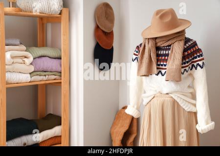 Mannequin avec accessoires, chandail chaud et jupe dans le dressing Banque D'Images