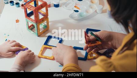 Enfant avec sa mère recueille un constructeur magnétique, gros plan, vue arrière Banque D'Images