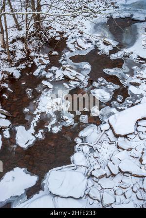 ruisseau gelé s'écoulant entre des roches bordées de glace recouvertes de neige fraîche. Spruce Creek, Kaaterskill Falls, Haines Falls, New York Banque D'Images