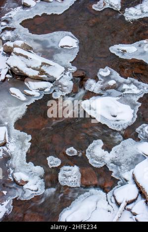 ruisseau gelé s'écoulant entre des roches bordées de glace recouvertes de neige fraîche. Spruce Creek, Kaaterskill Falls, Haines Falls, New York Banque D'Images