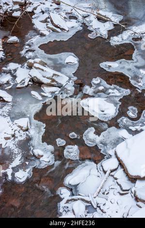 ruisseau gelé s'écoulant entre des roches bordées de glace recouvertes de neige fraîche. Spruce Creek, Kaaterskill Falls, Haines Falls, New York Banque D'Images