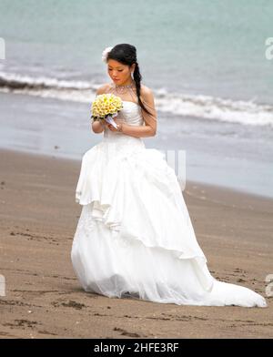 Une mariée asiatique à avoir des photos avant mariage prises sur Tuban Beach, Bali en Indonésie. Banque D'Images