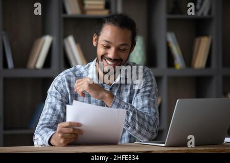 Joyeux étudiant africain gars lisant la lettre d'admission de l'école Banque D'Images