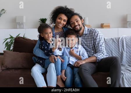 Heureux jeunes parents africains et deux petits enfants tenant les clés Banque D'Images