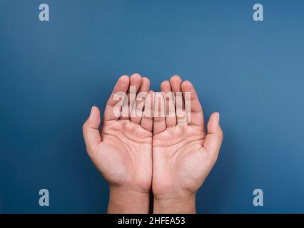 Deux mains libres se détendent en mouvement, isolées sur fond bleu, vue de dessus.Donner, demander, prier, faire un désir main, mendiant, concept de soins, outstre Banque D'Images