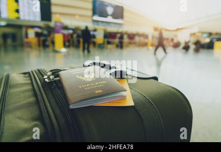 Passeport thaïlandais et passeport de vaccin sur les bagages sur fond flou de touriste dans l'aéroport.Certificat de vaccination pour le voyage pendant le Covid-19 Banque D'Images