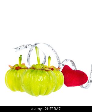 Garcinia cambogia fruits frais à coeur rouge et ruban de mesure, isolés sur blanc.Garcinia est des plantes épicées, contiennent de la vitamine C et de l'hydroxy citri Banque D'Images