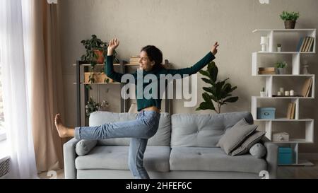 Joyeuse et énergique jeune femme célébrant la liberté à la maison. Banque D'Images