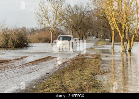 Voitures passant sur une route inondée en hiver.France, Europe. Banque D'Images