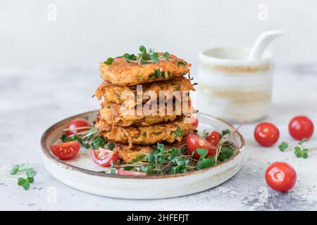 Beignets de pommes de terre aux herbes végétaliennes servis avec une salade fraîche Banque D'Images