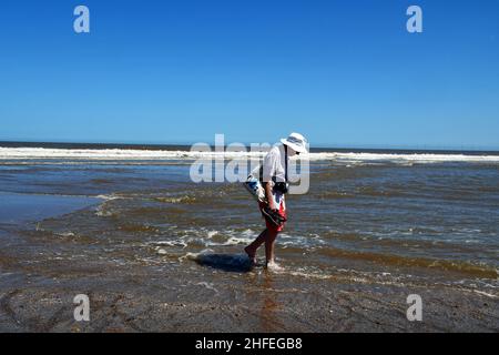 Homme pagayant dans la mer à Chapel six Marshes, Lincolnshire, Royaume-Uni Banque D'Images