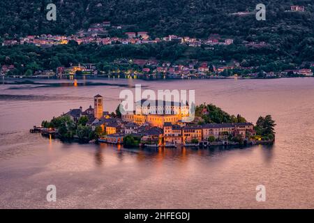 Vue aérienne de Sacro Monte sur l'île Saint-Julius avec basilique di San Giulio au milieu du lac Orta, illuminée la nuit. Banque D'Images