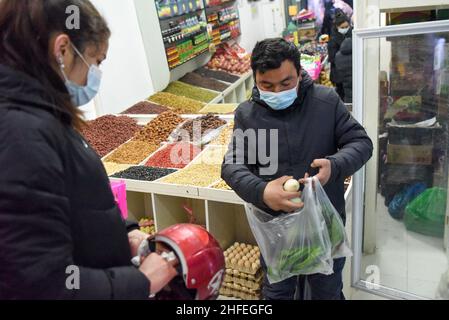 (220116) -- YUTIAN, le 16 janvier 2022 (Xinhua) -- Abudulezizi Maisedi (R) achète des légumes dans une rue commerciale du parc industriel de Tianjin, dans le comté de Yutian, dans la région autonome de Xinjiang Uygur, dans le nord-ouest de la Chine, le 13 janvier 2022.Le comté de Yutian, autrefois une zone pauvre du Xinjiang, a intensifié le développement d'industries à forte intensité de main-d'œuvre, notamment dans le textile, la confection de vêtements et la fabrication de chaussettes.Au parc industriel de Tianjin à Yutian, une base de production de la marque sportive chinoise Erke a été mise en service le 1 janvier 2022, offrant plus de 500 emplois aux habitants locaux.Maynurhan Amang et son mari Abudulezizi M. Banque D'Images