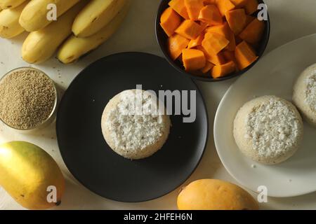 Gâteau à la farine de millet de baryard cuit à la vapeur ou puttu de millet de baryard servi avec des tranches de mangue et des plantains.Une variété de gâteau à la vapeur de riz Kerala avec baryard Banque D'Images