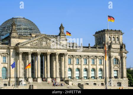 Vue de la façade extérieure du bâtiment Reichstag avec dôme en verre sur le toit en été. Une foule de gens font la queue à l'entrée. Fond ciel bleu clair. Banque D'Images