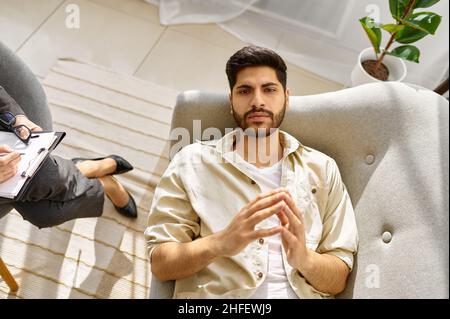 Un homme déprimé pensif se froissant en regardant le thérapeute Banque D'Images