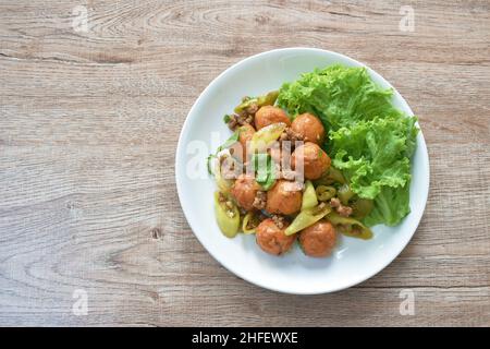 boule de tofu de poisson frite avec tranche de garniture de porc hache piment vert doux dans la sauce sur l'assiette Banque D'Images