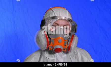 Virologiste scientifique en respirateur. Ralenti. Femme look rapproché portant un masque médical de protection. Concept sécurité sanitaire protection du virus N1H1 épidémie de coronavirus 2019 nCoV. Film bleu Chroma Key. Banque D'Images