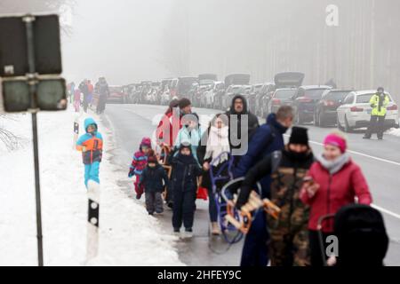 Hellenthal, Allemagne.16th janvier 2022.Les touristes de neige se préparent pour un voyage à l'Eifel couvert de neige dans la zone de ski et de luge de la 'Pierre Blanche', tandis que de nombreux véhicules sont déjà garés sur la route en raison de places de stationnement surpeuplées.De nombreux visiteurs sont dans la neige, même si les ascenseurs sont fermés.Crédit : David Young/dpa/Alay Live News Banque D'Images