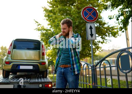 Triste homme et évacuation mauvaise voiture garée Banque D'Images