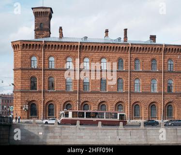 Vue sur la ville d'une maison en briques sur le remblai de la rivière Fontanka et d'un tramway. Banque D'Images