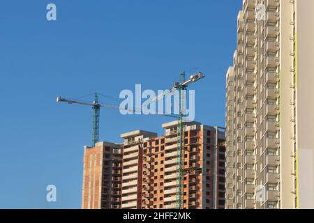 Nouveau bâtiment construction fond ciel bleu clair.Maison à plusieurs étages.Hypothèque.Tower Cranes chantier de construction entreprise de construction investissement immobilier Banque D'Images