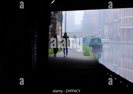 Silhouettes sous un pont à côté du canal Leeds-Liverpool dans le centre-ville de Leeds Banque D'Images