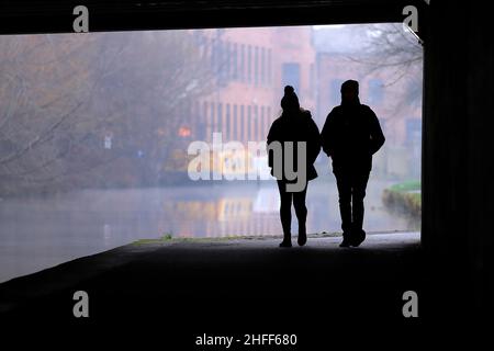 Silhouettes sous un pont à côté du canal Leeds-Liverpool dans le centre-ville de Leeds Banque D'Images